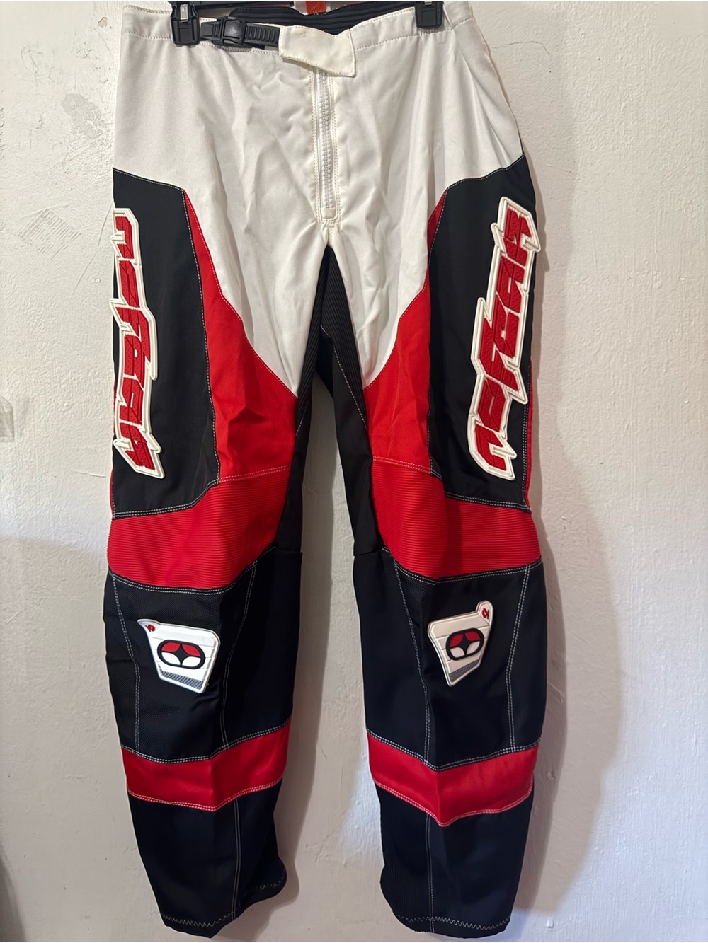 Red, black, and white No Fear motocross pants with red and black panels and whit